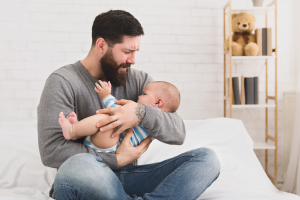 paternity leave - Father holding soothing baby